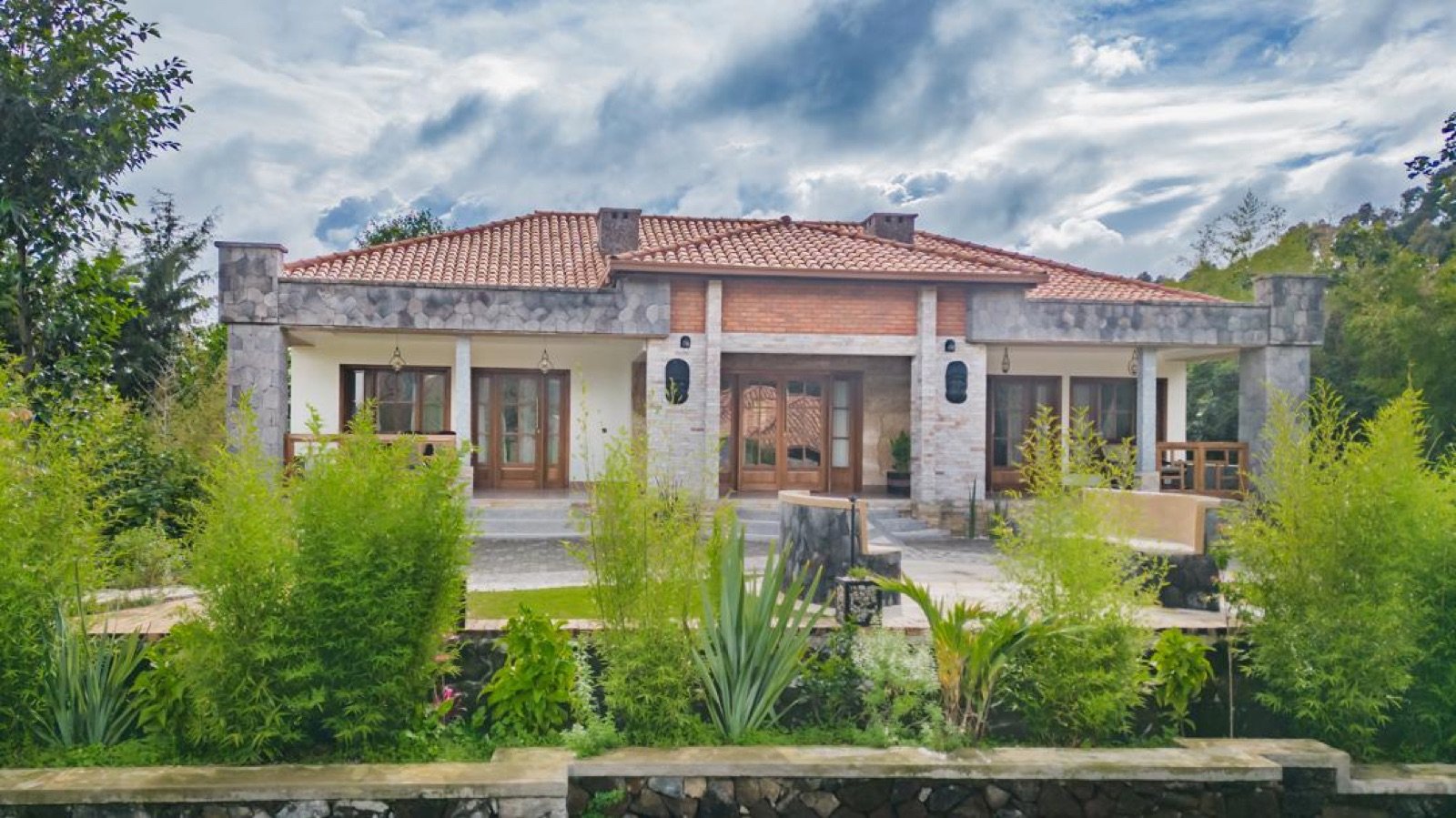 A single-storey stone and tile lodge with a garden at Ingagi Park View Lodge